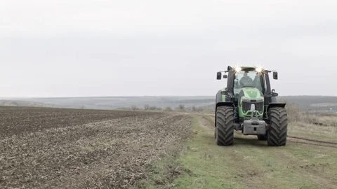 Modern tractor is going through field Stock Footage 70082624