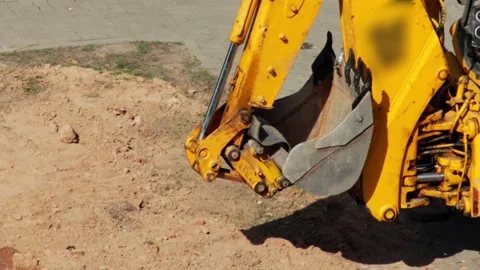 Modern tractor loader with yellow boom and bucket digs sand, close-up, industry Stock Footage 317090186