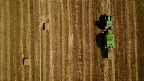 Modern tractor makes haystacks on the field after harvesting. Aerial top view. 스톡 동영상 89920457