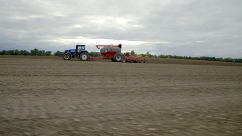 Modern Tractor Pulling High-Precision Air Seeder and Sowing Wheat in Farm Field Stock Footage 305168257