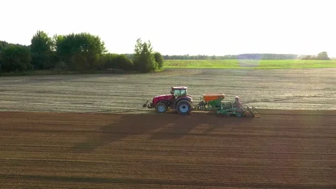 Modern tractor seeding agricultural field with plow and seed drill Stock Footage 314646853