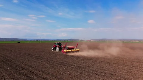 Modern Tractor Sowing Seeds in Large Agricultural Field for Spring Planting Stock Footage 334815780