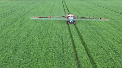 Modern Tractor Spraying Crops in Lush Green Field. Aerial Agriculture Concept Stock Footage 310036064