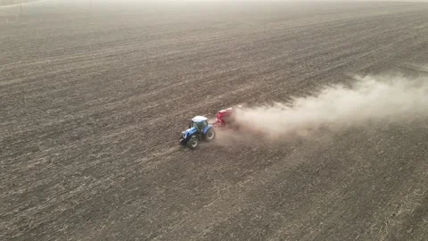 Modern tractor working plowing and sowing on the agricultural field - aerial  Video stock 141742441