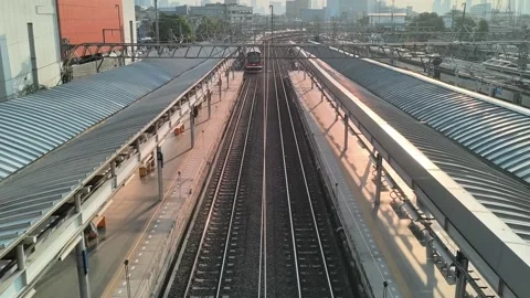 Modern Train Arriving at Elevated Station Amidst Cityscape Stock Footage 315621705