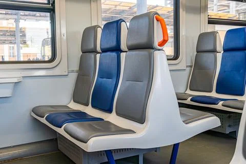 Modern Train Carriage Interior with Blue and Gray Seating Arrangement Stock Photos