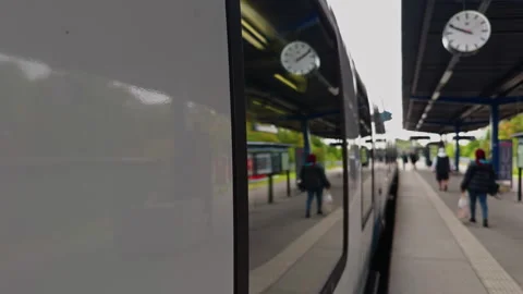 A modern train station features timely clocks and busy passengers on the move Vídeos de archivo 291971373