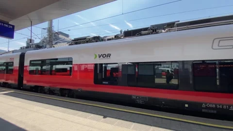 A modern train travels and stops on a platform at a train station Stock Footage 342281207