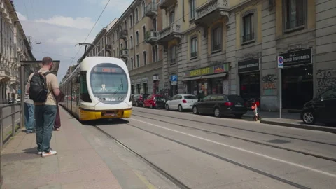 Modern tram arriving at stop in Milan residential district Stock Footage 337372877