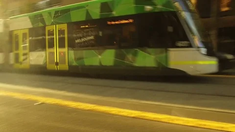 A modern tram comes out of the early morning Melboure sun Stock Footage 73860284