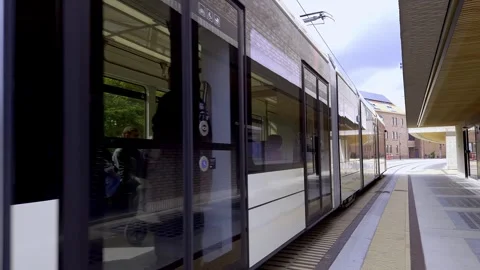 Modern Tram Departing Stop in restad, Copenhagen, Denmark Stock Footage 336023542