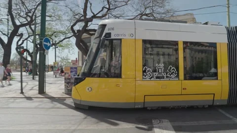 A modern tram passes front of the Cais do Sodré railway station Lisbon Portugal Stock Footage 273426858