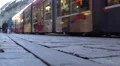 Modern tram passing crowded street in old city downtown, public transportation HD Footage
