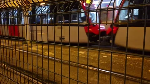 Modern Tram Passing Through Station at Night - Urban Transportation Stock Footage 326645317
