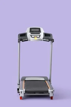 Modern treadmill on lilac background Stock Photos