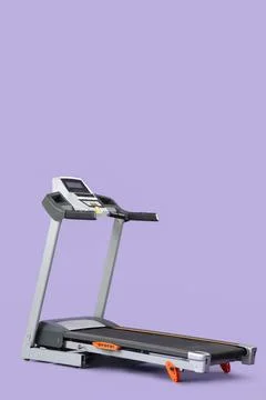 Modern treadmill on lilac background Stock Photos