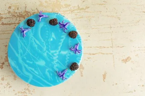 Modern trendy mousse cake with blue marble mirror glaze. Flowers and blackb.. Stock Photos