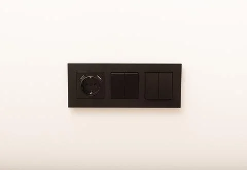Modern triple wall socket panel with power outlet and light switches. Black.. Stock Photos
