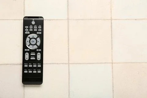 Modern TV remote control on light tile background Stock Photos