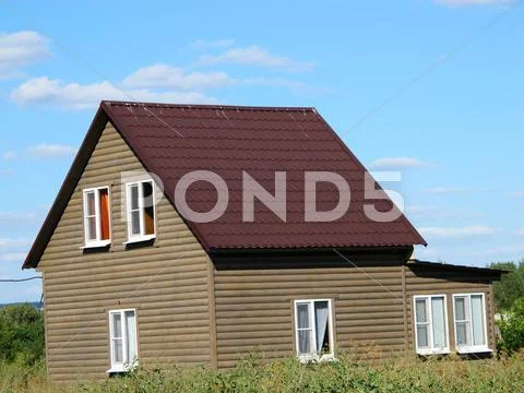 Modern Two-Storeyed Summer Cottage Against A Blue Sky