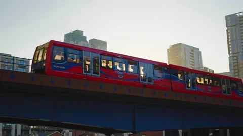 Modern urban DLR Train, TFL running between skyscrapers in Canary Wharf, London. Stock Footage 145299396