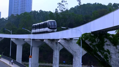 Modern urban elevated skyrail monorail train traveling through green city landsc Stock-Footage 333268963