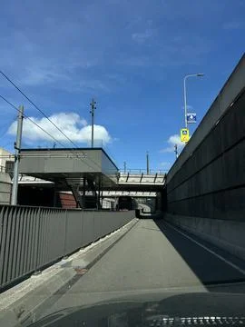Modern urban tram corridor with elevated bridge, empty asphalt lane, overhead Foto stock