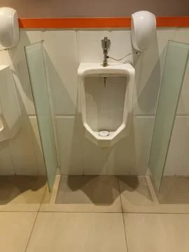 Modern Urinal with Partitions and Automatic Hand Dryer in a Public Restroom Stock Photos