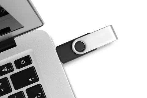 Modern usb flash drive attached into laptop on white background, top view Stock Photos