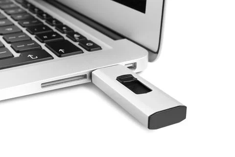 Modern usb flash drive attached into laptop on white background, closeup Stock Photos