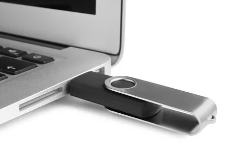 Modern usb flash drive attached into laptop on white background, closeup Stock Photos