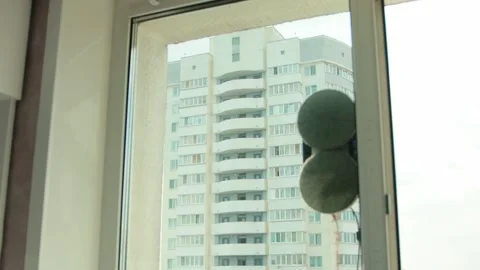 A modern vacuum robot window cleaner washes glass from dirt and stains on a pvc Stock Footage 253470779