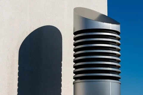 Modern ventilation cylindrical pipe casting shadow on wall Stock Photos