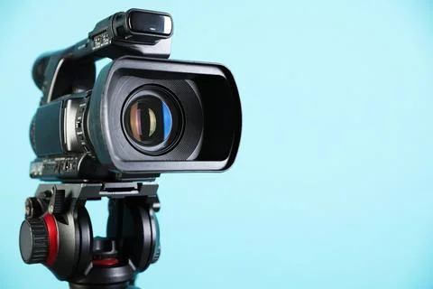 Modern video camera on light blue background, closeup. Space for text Stock Photos