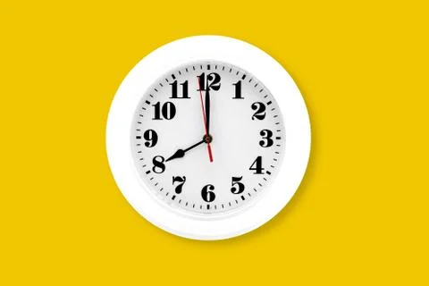 Modern wall clock white isolated on yellow background, time and period, offic Stock-Fotos
