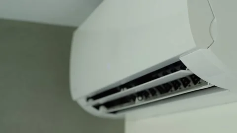 Modern wall mounted air conditioner unit opening louver blades to start coo.. Stock Footage 334560738