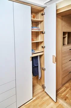 Modern wardrobe with finger pull design. Wooden wardrobe with light gray cabi Stock Photos