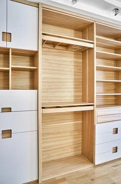 Modern wardrobe with finger pull design. Wooden wardrobe with light gray cabi Stock Photos