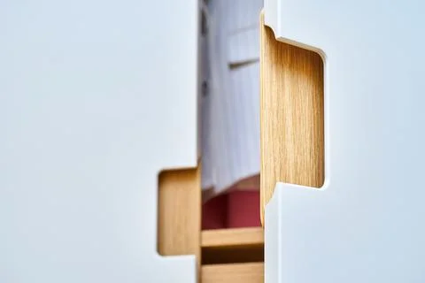 Modern wardrobe with finger pull design. Wooden wardrobe with light gray cabi Stock Photos