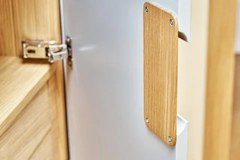 Modern wardrobe with finger pull design. Wooden wardrobe with light gray cabi Stock-Fotos