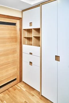 Modern wardrobe with finger pull design. Wooden wardrobe with light gray cabi Stock Photos