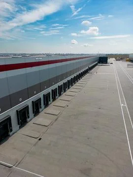 Modern warehouse loading docks under a bright sky.  Efficient logistics and.. Stock Photos