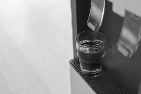 Modern water cooler with glass indoors, closeup. Space for text Stock Photos