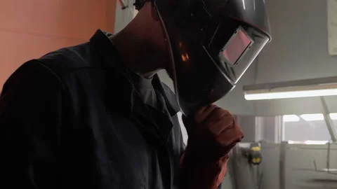 Modern welder puts on a technological helmet and starts welding parts. Stock Footage 212385145
