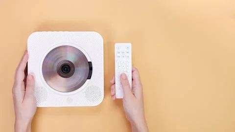Modern White CD Player with Remote Control on a Yellow Background, Minimalist Stock Photos