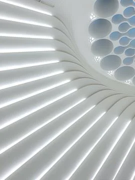 A modern white ceiling with a unique design, featuring curved lines and a c.. Stock Photos