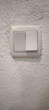 Modern white double light switch on white stucco wall. 스톡 사진