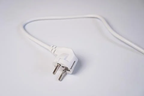A modern white electrical power plug connector lying disconnected with its .. Stock Photos