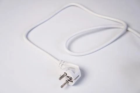 A modern white electrical power plug connector lying disconnected with its .. Stock Photos