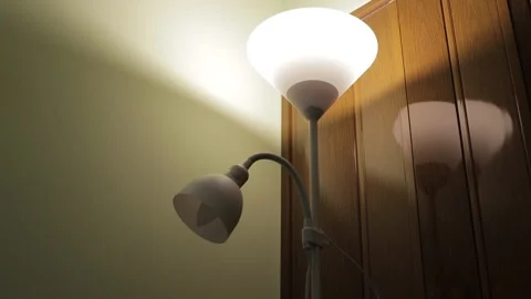 Modern white floor lamp with two light bulbs switching on and off in a dark room Stock Footage 322098653